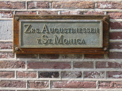 847167 Afbeelding van het naambordje 'Zrs. Augustinessen v. St. Monica', geschroefd op de werfmuur onder het klooster ...